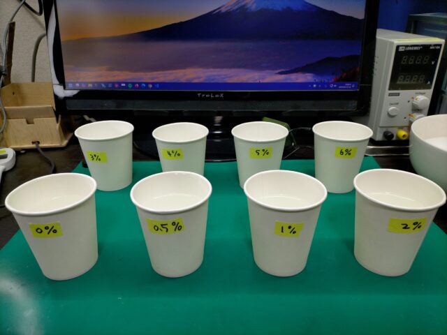 塩分濃度0%から6%までの試験塩水の入ったコップ